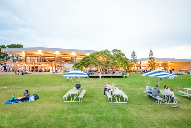 Sandstone Point Hotel: People enjoying a picnic and outdoor dining on a grassy lawn.