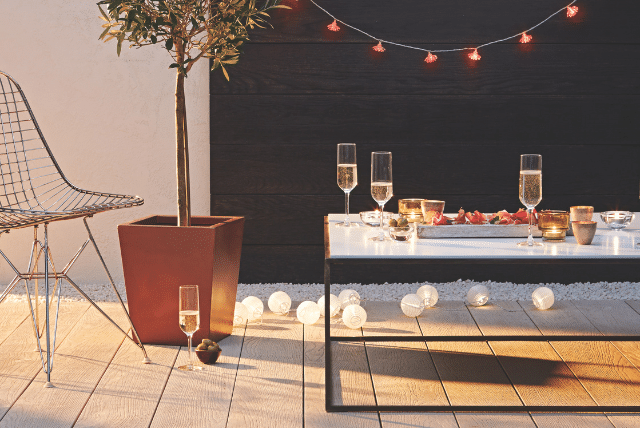 Get Holiday-Ready with Millboard Decking Installation This Season 1 Concept Materials Composite Decking Stylish Millboard decking installation with champagne glasses, lights, and a modern outdoor setup for holiday entertaining.
