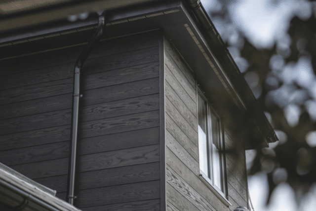 How Contemporary Design Materials Define Signature Spaces 1 Concept Materials Composite Decking Modern house exterior with dark wood-look contemporary design materials and white window frame.