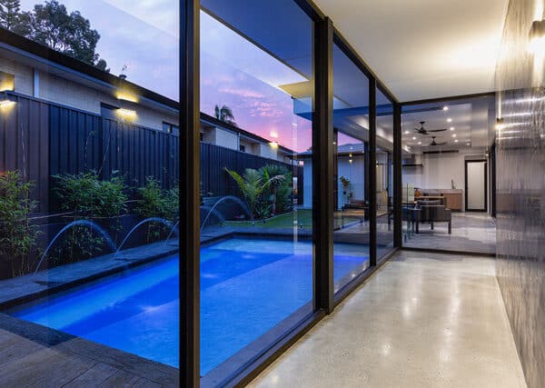 Modern pool and indoor-outdoor living space with low maintenance decking.