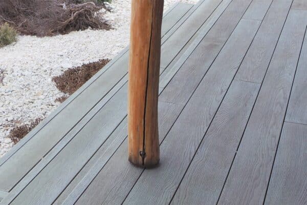 Timeless Outdoor Design: How Composite Decking Designs Elevate Form and Function 2 Concept Materials Composite Decking Composite decking designs featuring a wooden support post on a gray deck, with white gravel in the background.